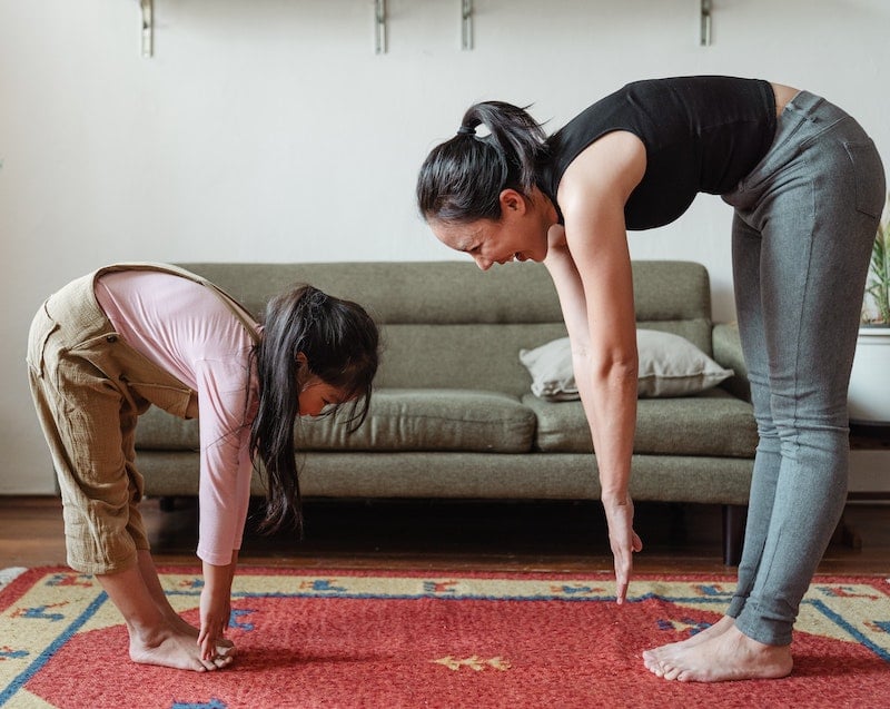 mum stretching to touch her toes with daughter doing the same
