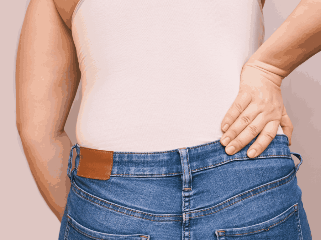 woman holding back next to hip