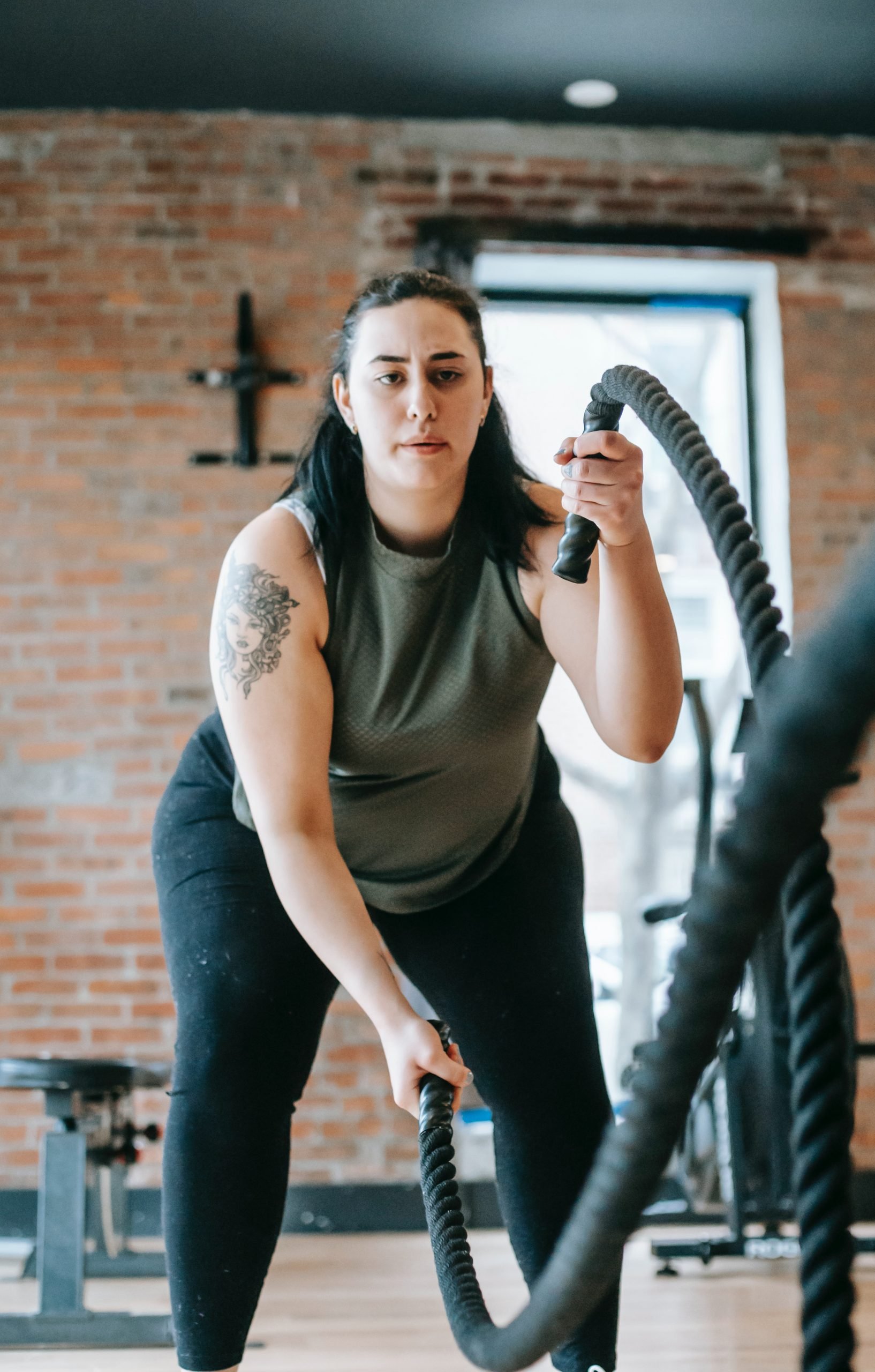 woman doing an intense workout with heavy ropes