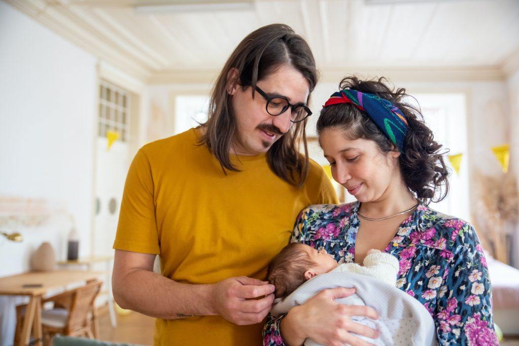 Parents looking at their newborn. Dads feel a lot of things in postpartum, too. 